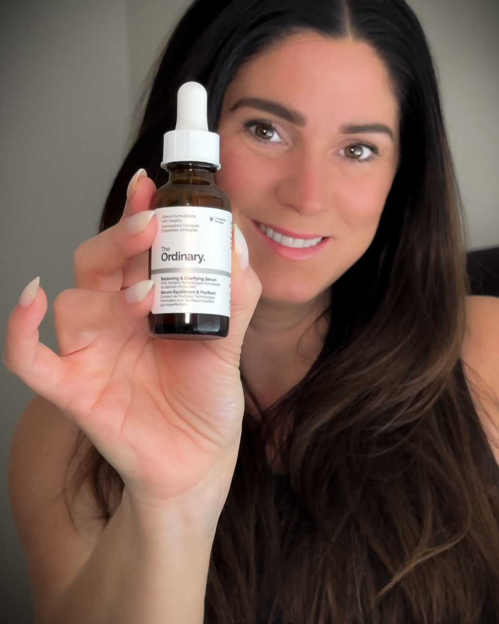 UGC creator, Jamie showcasing a bottle of The Ordinary balancing and clarifying serum to the camera.